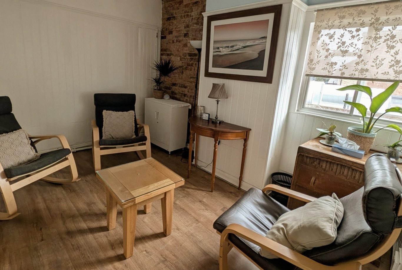 Photo of a person on a videocall on a laptop to a man. An open book is beside the laptop. We see this from over the shoulder of the caller.