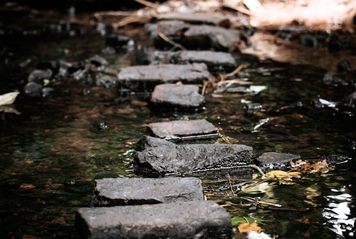 Photo of a silver padlock with two keys attached on top of the edge of a Mac laptop keyboard on a wood table, representing digital security.
